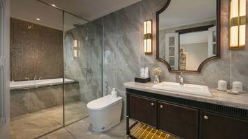 A modern bathroom with a glass-enclosed shower, a freestanding bathtub, a vanity with a sink, and a large mirror.
