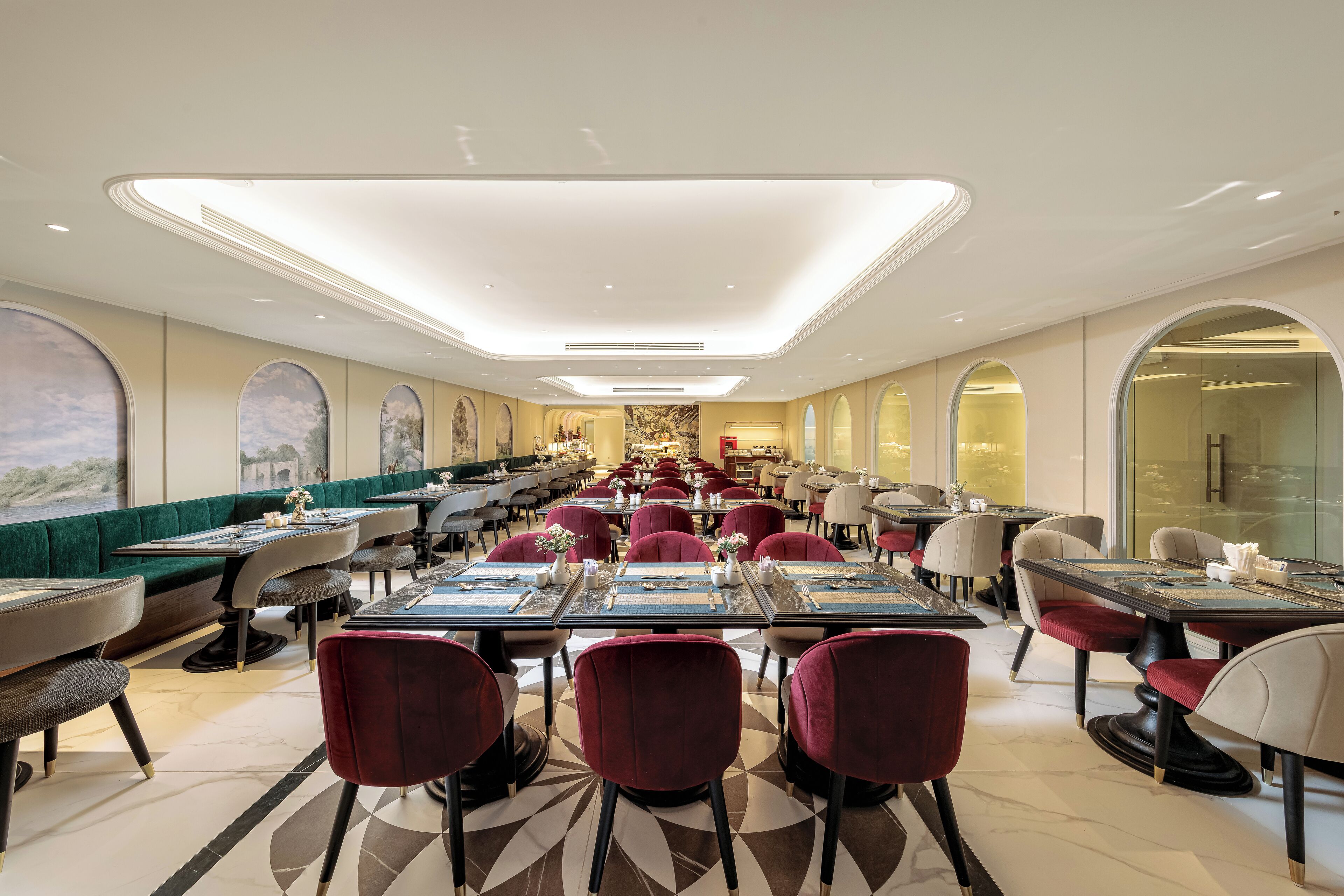 A spacious restaurant with high ceilings, modern lighting, and a variety of seating arrangements including booths and tables.