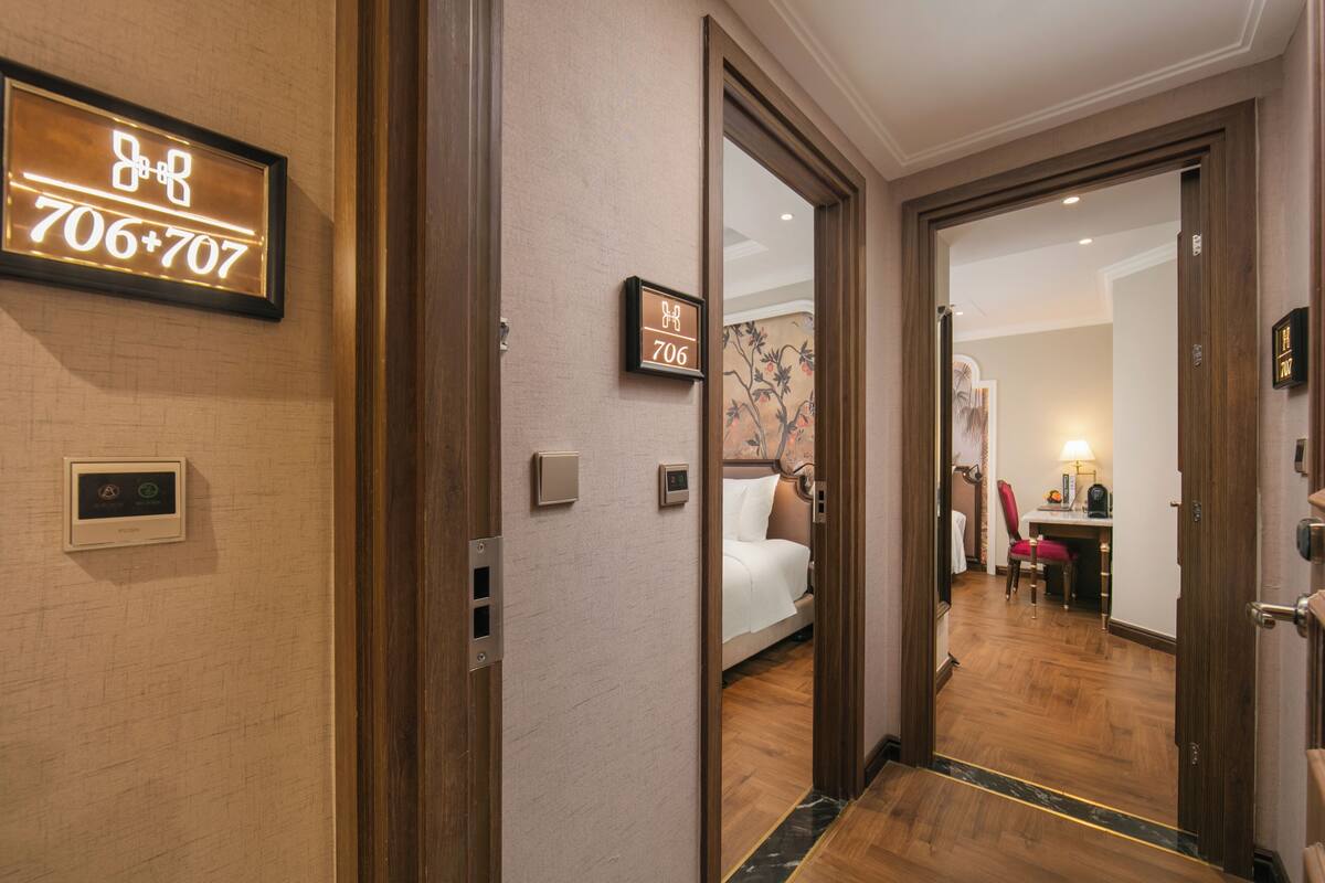 Een hotelgang met een bed, een bureau en een stoel in de kamer.