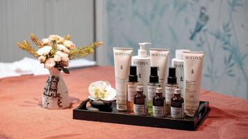 A tray with various Sothys Paris skincare products and a vase with flowers on a textured surface.