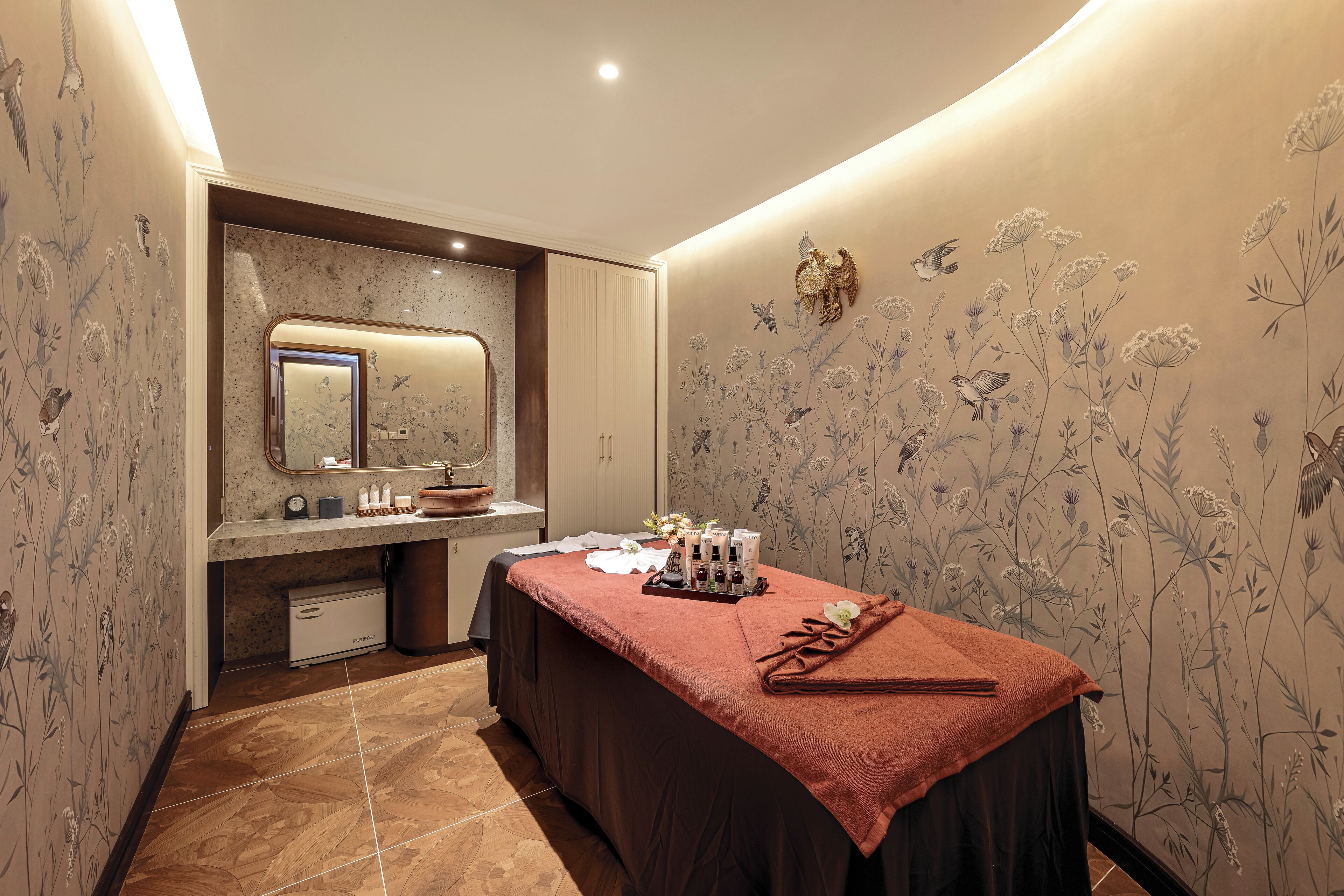 Un cuarto de spa con una camilla de masaje, un lavabo y un espejo.