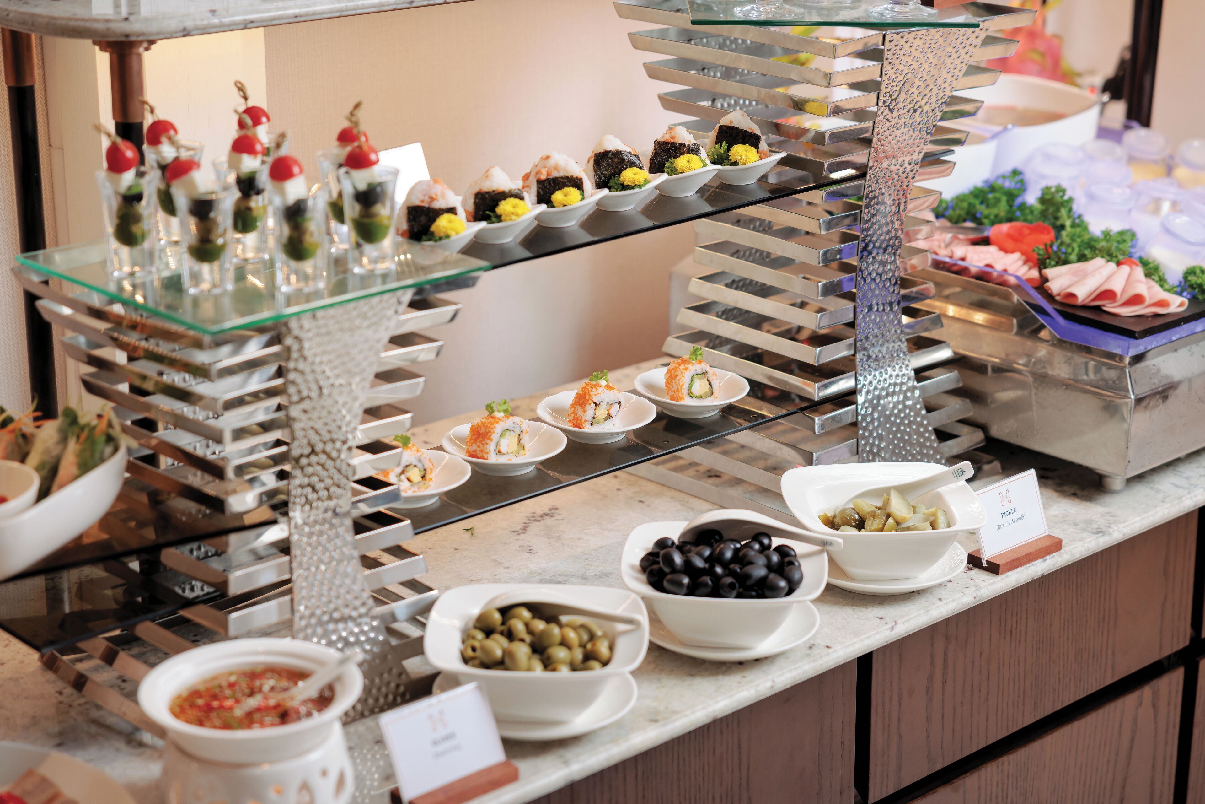 A buffet with various food items including sushi, olives, and a salad.