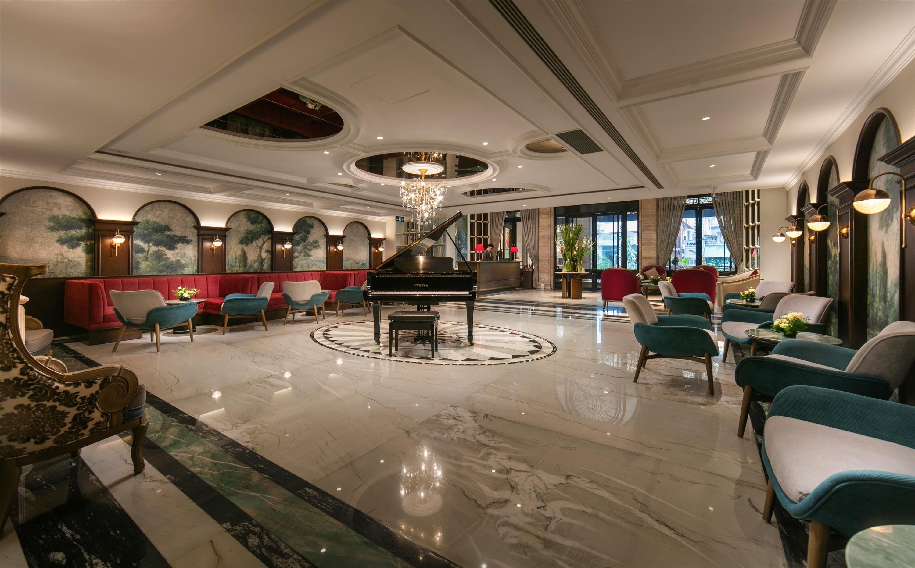 A grand lobby with a grand piano, plush seating, and a chandelier.