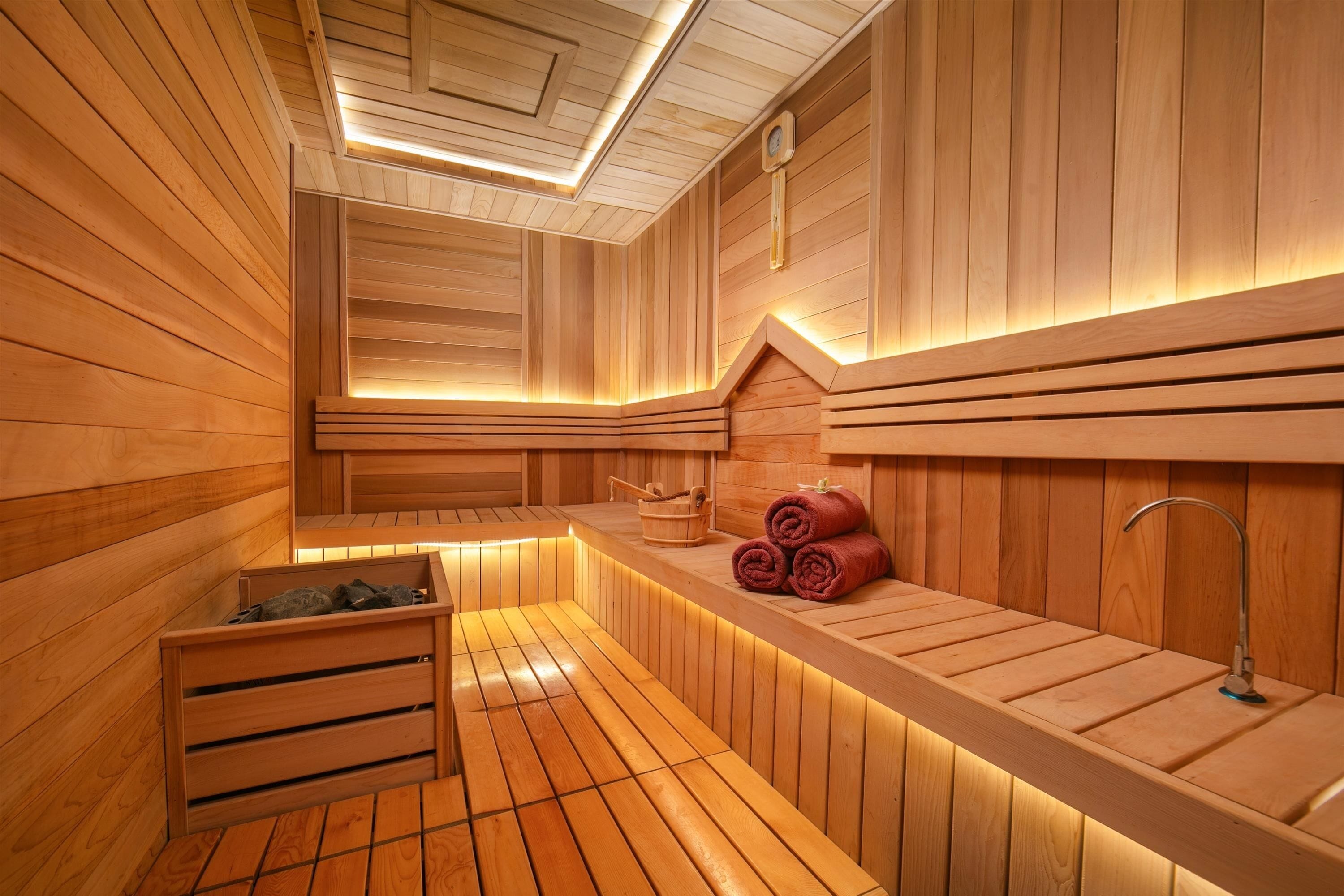 Eine Holzsauna mit Bänken und einem Waschbecken.