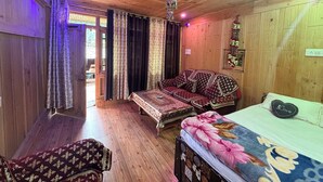 Habitación con piso de madera, un sofá, una cama y un sillón.
