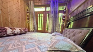 Un dormitorio con cama, paredes de madera y vistas por una ventana.