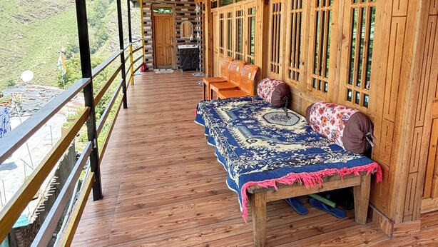Una terraza de madera con una cama, almohadas y un par de zapatillas.