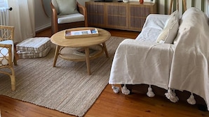 Un salon moderne comprenant un téléviseur, un canapé, un fauteuil, une table basse et une lampe.