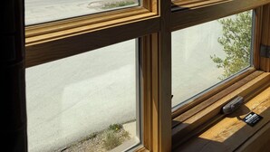 Ein Fenster mit Blick auf ein Gebirge, einen Fluss und eine Straße.