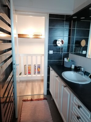 A modern bathroom with a white sink, black countertop, and a mirror.