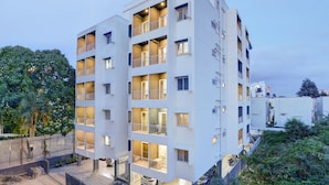 A multi-story residential building with balconies, a gated entrance, and a parking area. - Acasa Suites ITPL Whitefield (Bengaluru)