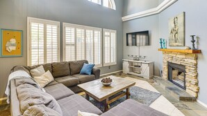 A living room with a sectional sofa, a coffee table, a fireplace, and a television. - Hike & Golf! Townhouse w/ Resort Perks in PHX (Phoenix)