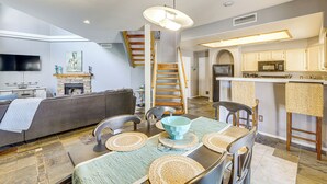 A modern kitchen with a microwave, stove, and bar area. There is a dining table with chairs and a sofa in the living area. - Hike & Golf! Townhouse w/ Resort Perks in PHX (Phoenix)