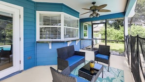 A covered patio with blue walls, wicker furniture, and a ceiling fan. - 6 Mi to St Lucie River: Family Home w/ Patio! (Port Saint Lucie)