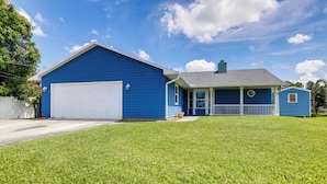 A two-story house with a blue exterior, a white garage door, and a small attached garage. - 6 Mi to St Lucie River: Family Home w/ Patio! (Port Saint Lucie)