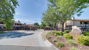 A street view with a sidewalk, parked cars, and a sign for 'Shady Inn & Suites'. - 10 Mi to Dtwn Tulsa: Condo w/ Pool Access! (Tulsa)