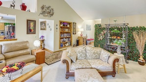 A living room with a sofa, a coffee table, a bookshelf, and a decorative wall. - 5 Mi to Platte River: Inviting Bellevue Rental (Bellevue)