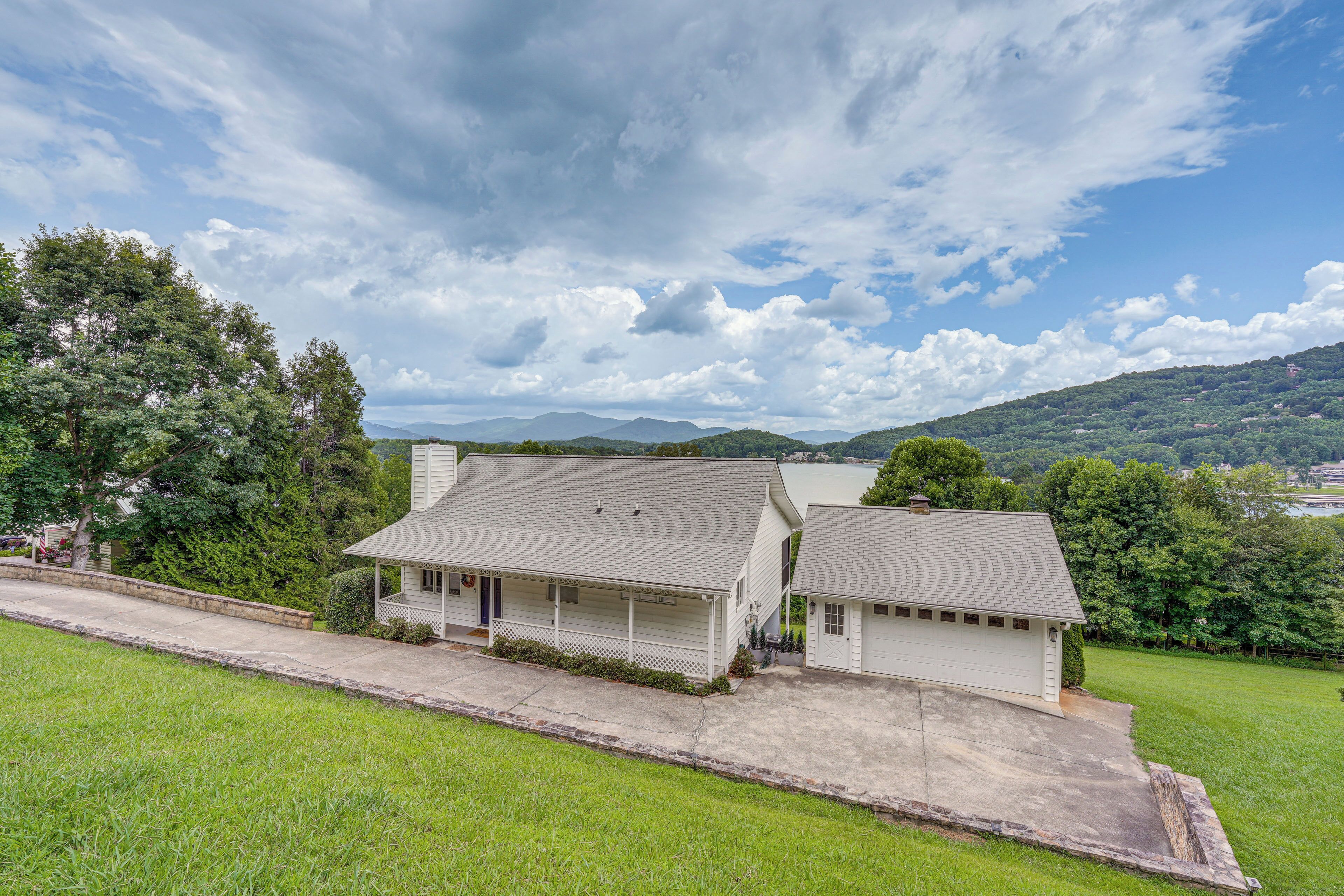 A two-story house with a covered porch, a garage, and a well-maintained lawn.