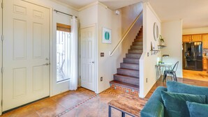 A spacious living area with a wooden staircase, a dining table, and a kitchen with modern appliances. - Southwestern Chic! Tucson Retreat w/ Private Patio (Tucson)