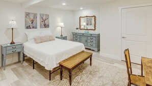 A bedroom with a bed, bedside tables, a bench, a dresser, a chair, and artwork on the walls. - Joliet Main Street Retreat < 30 Mi to Red Lodge (Joliet)