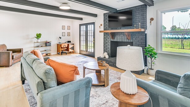 A modern living room with a fireplace, seating area, and a view of a green field. - Pet-friendly Home w/ Yard, 1 Mi to Decatur Mall (Decatur)