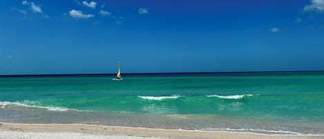 Una playa cerca, sillas reclinables de playa, toallas de playa