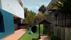 A courtyard with artificial grass, a play structure, and a series of circular obstacles. - Breeze Residence duplex penthouse, Belém do Pará, for cop30 (Val-de-Cans Belém)