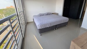 A modern bedroom with a large bed, a nightstand, and a wardrobe.
