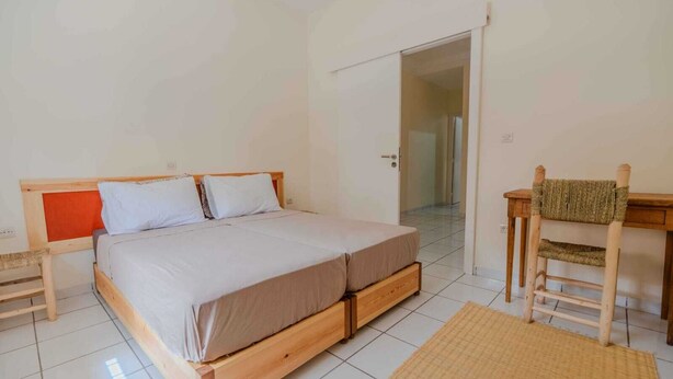 A bedroom with a wooden bed, a desk, and a chair. - A beautiful apartment for rent with everything you need. (Essaouira)