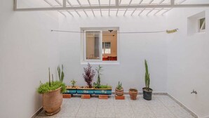 A room with a skylight, a window, and potted plants. - A beautiful apartment for rent with everything you need. (Essaouira)
