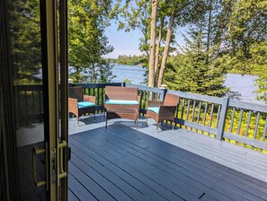 A deck with wicker furniture and a view of a lake. - Cozy Haven - Little Lakefront Home (Little Lake)