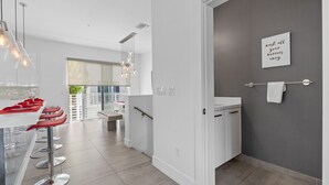 Une cuisine moderne avec un coin bar, un mur d’accent de couleur grise et une vue sur l’extérieur.