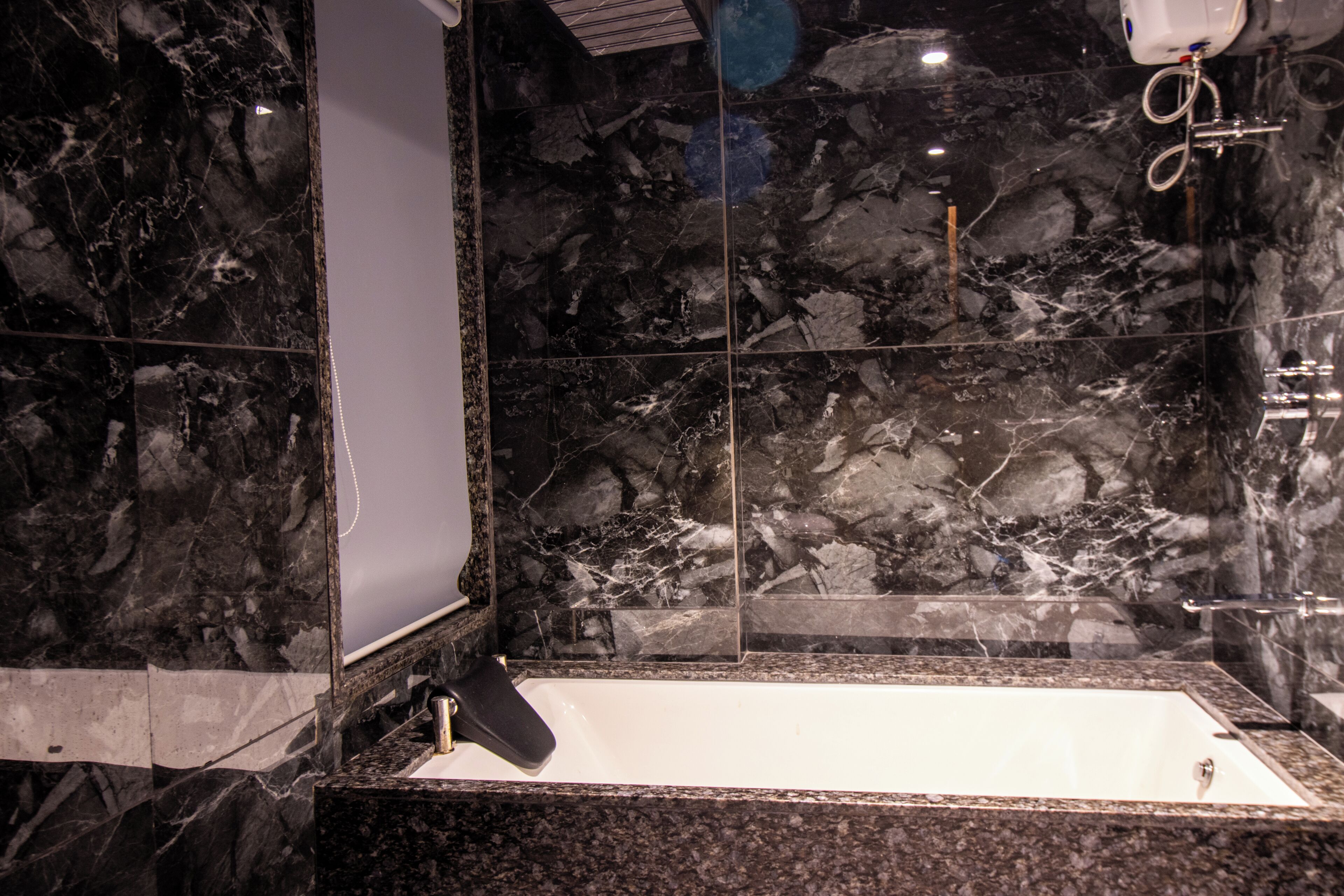 Un baño con lavamanos de mármol, bañera y espejo.
