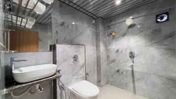 Un bagno moderno con una parete in marmo, un lavandino bianco e un water.
