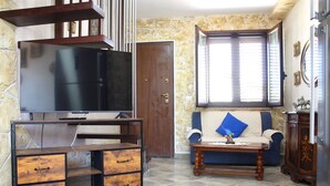 A living room with a TV on a stand, a sofa, a coffee table, and a cabinet. - RIVER VIEW CHARMING VILLA IN AMAZING ALGHERO WITH AC (Alghero(SS))