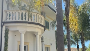 A two-story building with a balcony, columns, and potted plants. - Corte Vena Palace (Bianco)