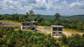 Two modern cabins with glass walls, situated in a forested area with a view of rolling hills. - Cabin with Views, Views, Views (Ocoee)