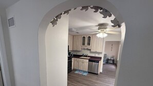 Una cocina con gabinetes de madera, lavavajillas y ventilador de techo.