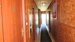 A hallway with wooden walls and doors, a carpeted floor, and a ceiling with recessed lighting. - Nature & Fishing Retreat in Kołczewo (Kołczewo)