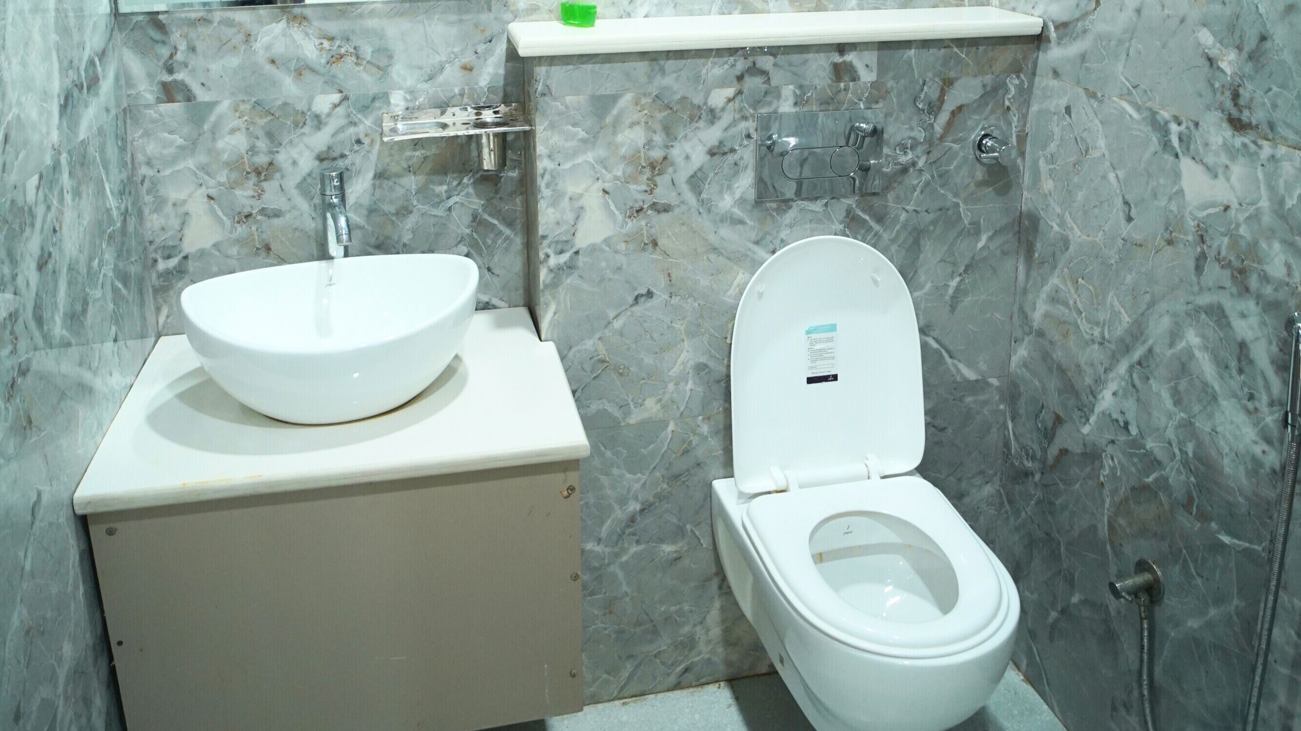 A bathroom with a white toilet and a white sink on a marble countertop.