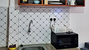 A kitchen with a granite countertop, a sink, a microwave, and a spice rack. - Cozy and Affordable  studio in Kasarani, Seasons,near Thika Road, Nairobi (Nairobi)