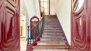 A grand staircase with ornate railings and a polished wooden finish.