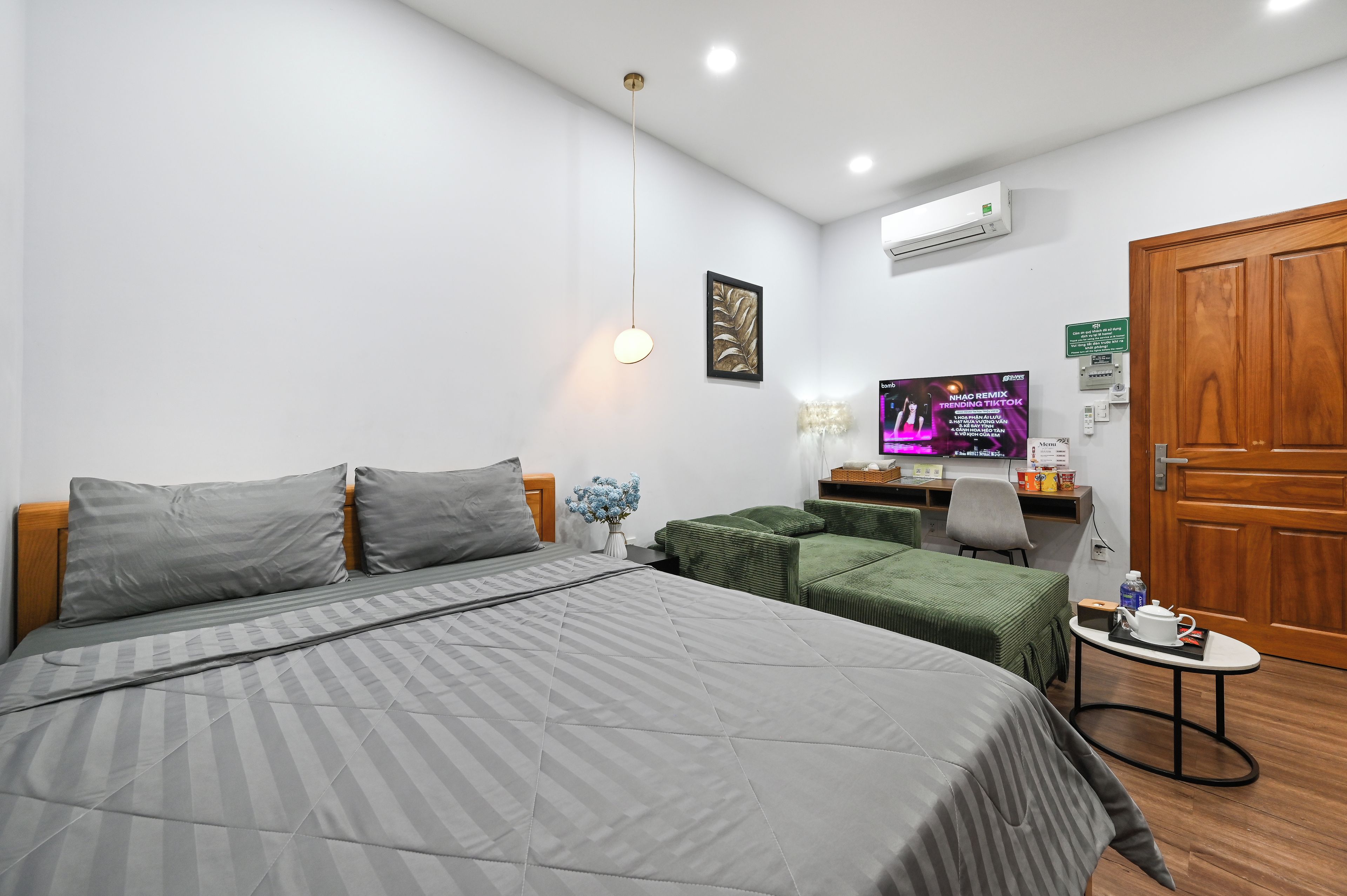 A hotel room with a bed, a desk, a television, and a wardrobe.