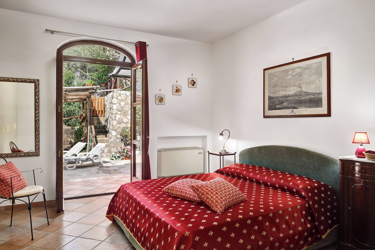 Une chambre à coucher avec un lit, une chaise, un bureau et une vue sur l’extérieur.