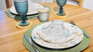 A dining table set with plates, cutlery, and glassware. - Charming loft in BH (Nova Esperança Belo Horizonte)