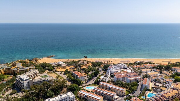 A coastal resort with beachfront villas, a sandy beach, and a clear view of the ocean.