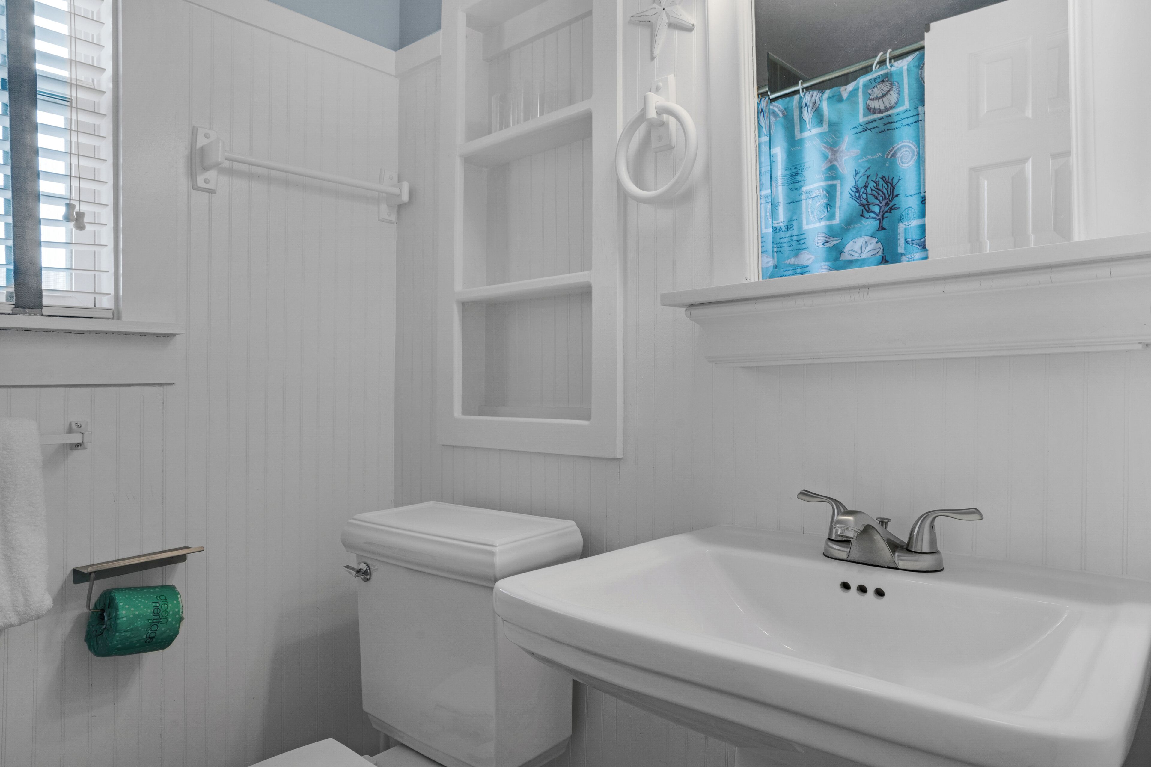 A bathroom with a toilet, sink, and towel rack.