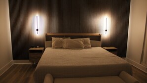 A neatly arranged bedroom with a large bed, two bedside tables, and a bench in front of the bed. - Cozy Home in Baton Rouge (Baton Rouge)