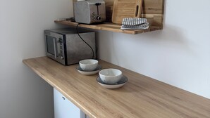A compact kitchenette with a wooden countertop, a microwave, a toaster, and two bowls. - Cosy studio in quiet location, Questembert town center (Questembert)