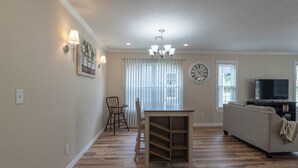 A living room with a dining table, sofa, and TV.